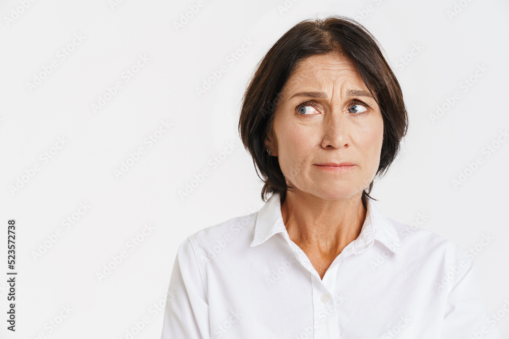 Mature brunette woman frowning and looking aside Mature brunette woman frowning and looking aside