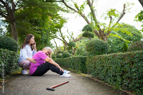 Принти на полотні Asian senior woman fell down on lying floor because faint and limb weakness and pain from accident and woman came to help support and call emergency