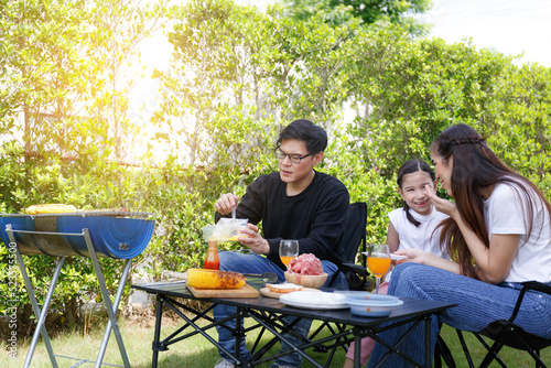 Asian family happy bright cute daughter Barbecuing in the courty photo