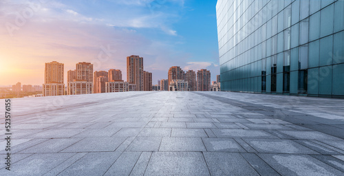 Fototapeta Naklejka Na Ścianę i Meble -  Empty floor and modern city skyline with building scenery at sunset