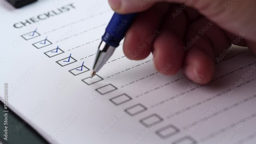 Checklist and To Do List Concept. After finishing a job on white paper, a close-up businessman ticks off or marks it with red mark on checklist, checkbox, to-do list box. selective focus 4K