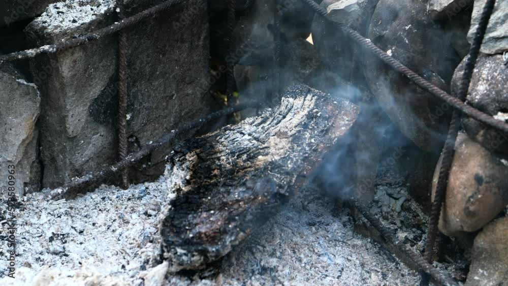 Scorched smoking log on the outdoor grill in nature Scorched smoking log on the outdoor grill in nature