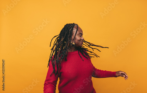 Foto Joyful black woman whipping her dreadlocks in a studio
