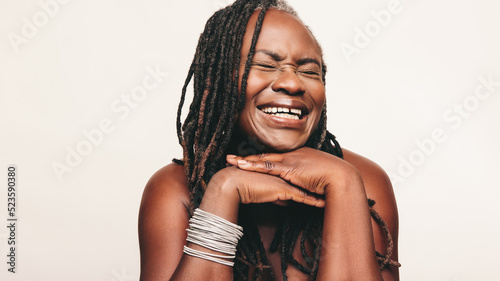 Joyful woman laughing happily against a studio background photo