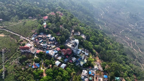 Aerial Panning Shot Of Houses In Town On Green Mountain Top - Munnar, Kerala photo