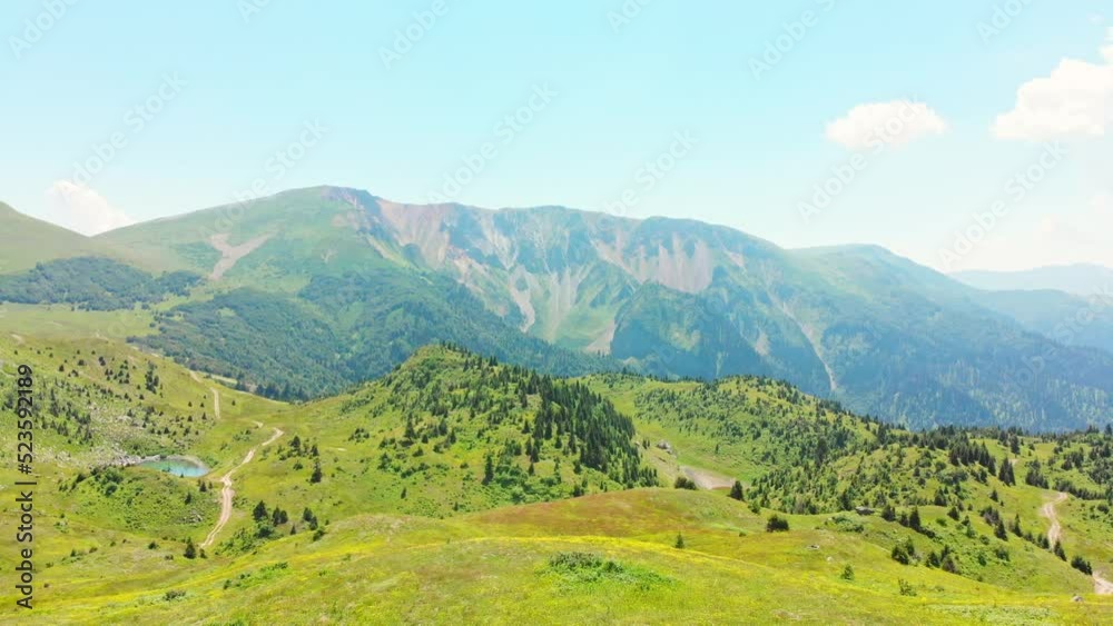 Aerial zoom out view over female hiker with backpack stand on edge admire beautiful green nature outdoors. Adjara region, Caucasus, Georgia Aerial zoom out view over female hiker with backpack stand on edge admire beautiful green nature outdoors. Adjara region, Caucasus, Georgia