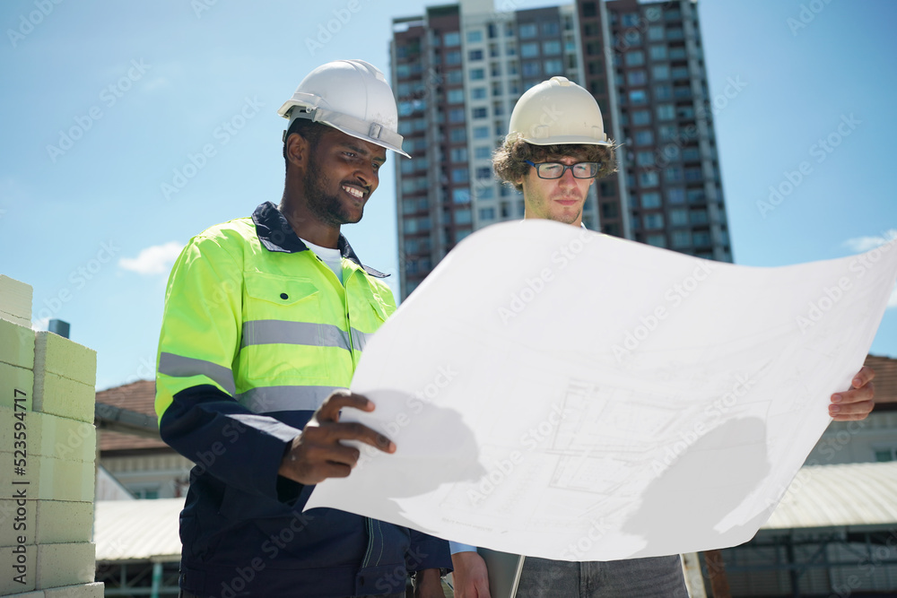 Architect and construction engineer or surveyor discussion plans and blueprints