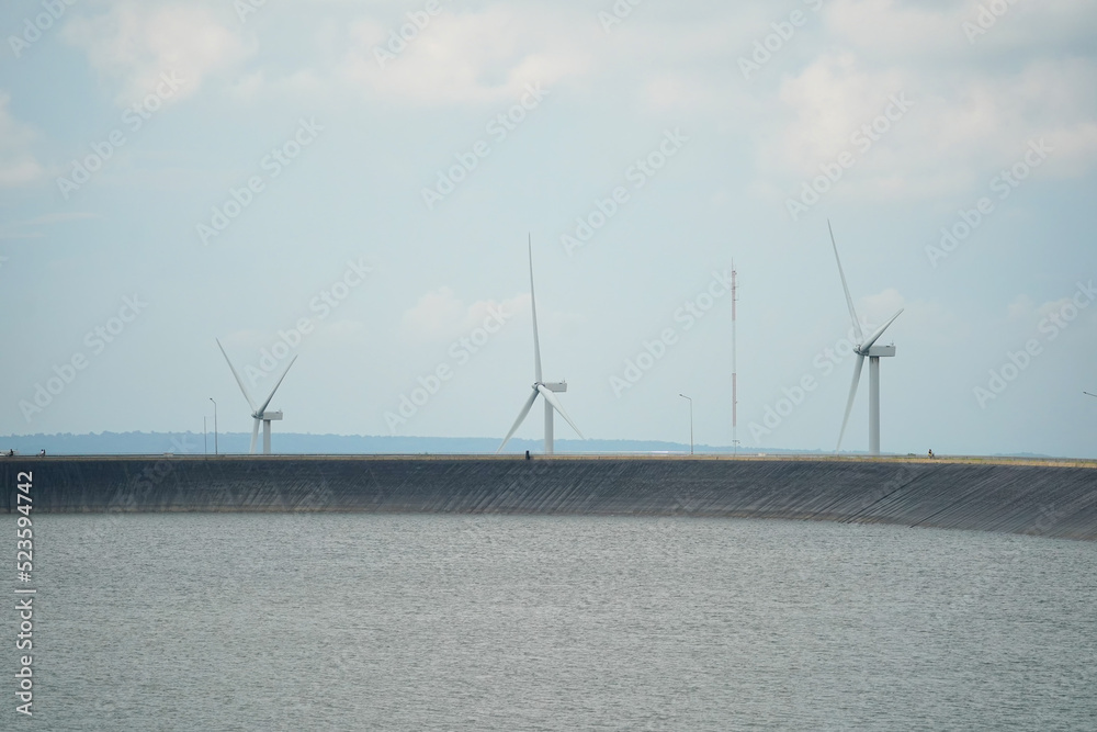Windmills wind turbines farm power generators. Production of renewable green energy