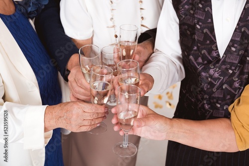 Photos Group of older happy friends toasting with champagne during New Year's Eve