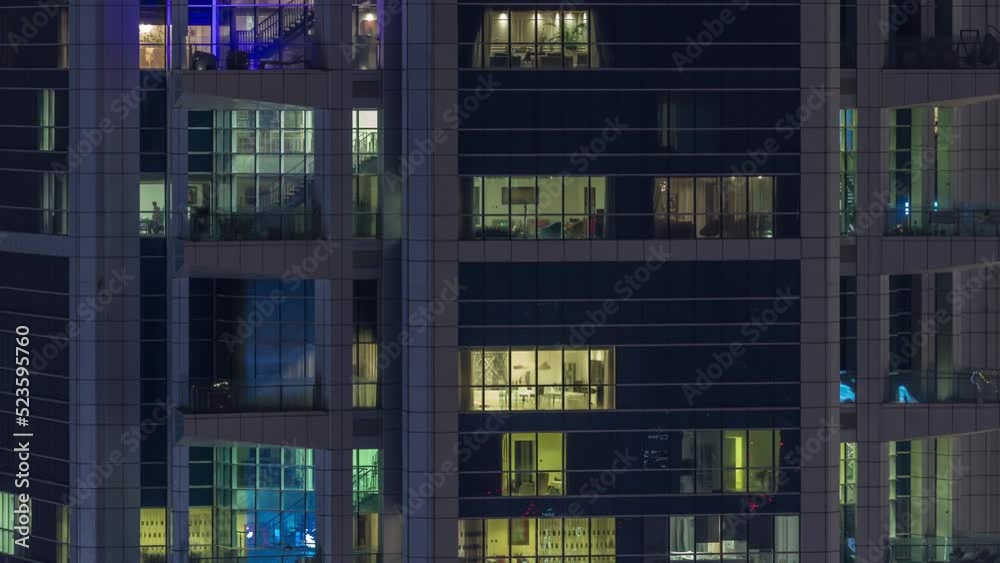 Windows in high-rise building exterior in the late evening with glowing and blinking interior lights on timelapse. Aerial top view