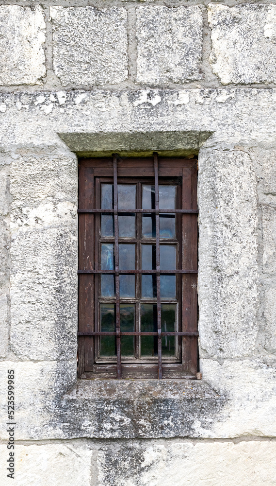 a window with bars on the old castle is shot close-up