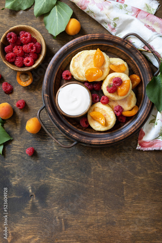 Healthy and delicious morning breakfast. Homemade cottage cheese pancakes gluten free (syrniki, curd fritters) with berries on wooden rustic background. View from above. Copy space.