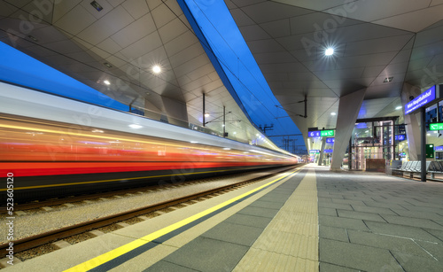 Canvas Print High speed train in motion on the railway station at night