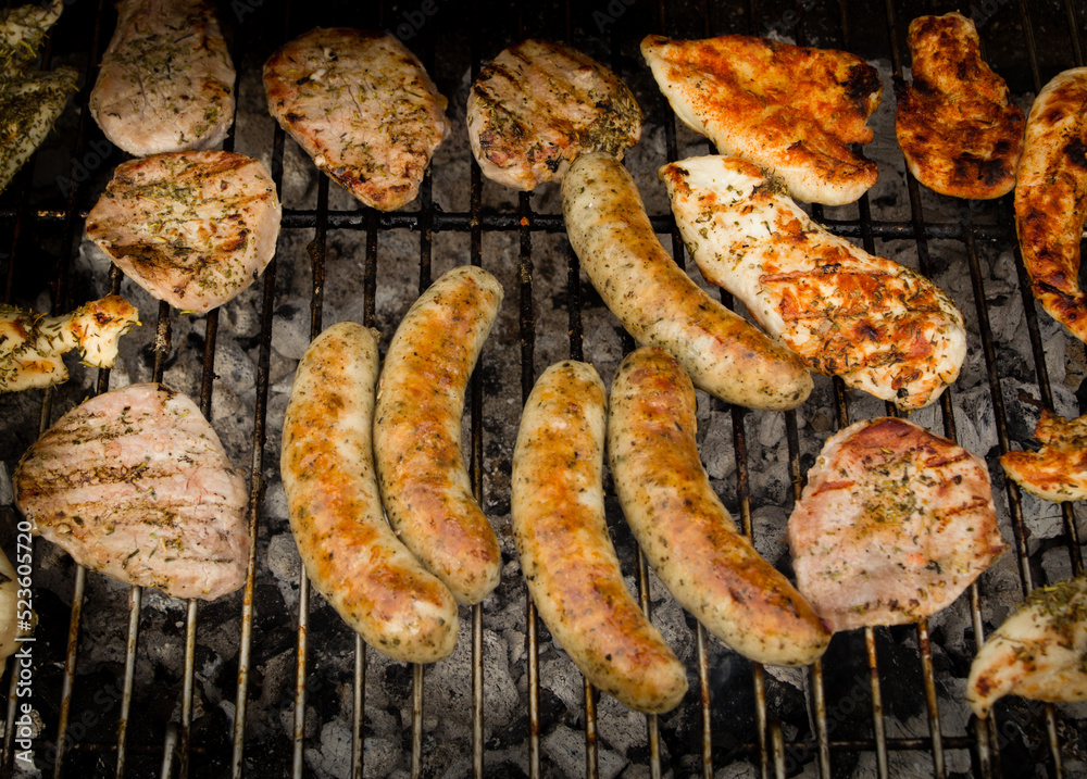 Closeup shot of grilled sausages and meat on the grill