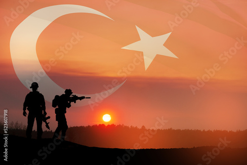 Silhouettes of soldiers on a background of Turkey flag and the sunset or the sunrise. Concept of crisis of war and conflicts between nations. Greeting card for Turkish Armed Forces Day, Victory Day.