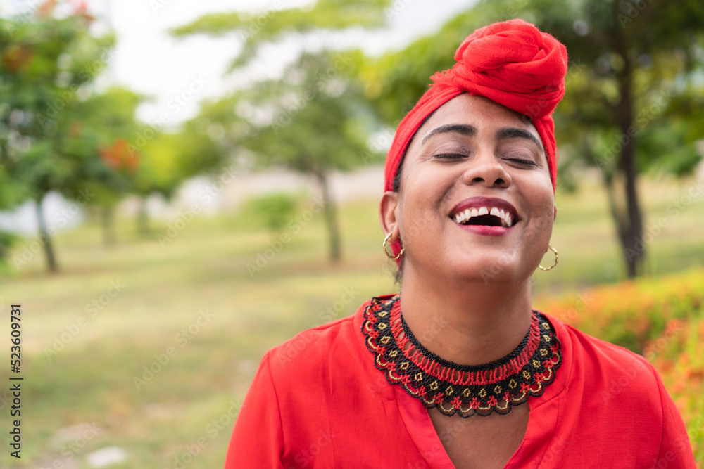 Latina woman smiling while standing in park