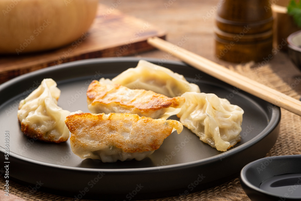 gyoza,Japanese style grilled dumplings with pork and vegetables on black plate gyoza,Japanese style grilled dumplings with pork and vegetables on black plate