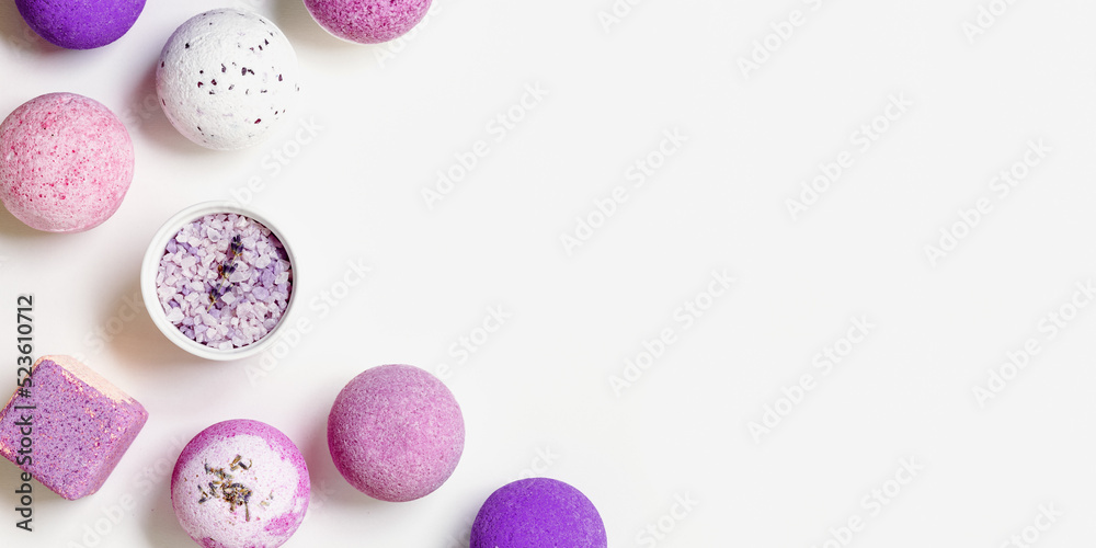 Fragrant and healthy spa products with essential oil, bath bombs and sea salt on white background. Aromatherapy and herbal medicine, cosmetics products for body treatment, top view banner Fragrant and healthy spa products with essential oil, bath bombs and sea salt on white background. Aromatherapy and herbal medicine, cosmetics products for body treatment, top view banner