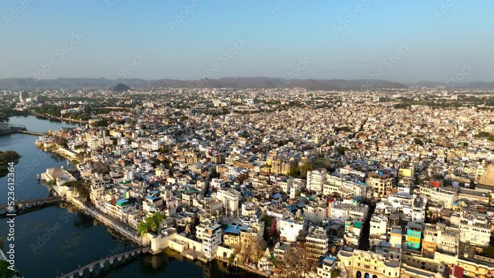 Aerial Shot Of Residential Buildings On City Landscape, Drone Flying Forward Over Lake During Sunny Day - Udaipur, India Aerial Shot Of Residential Buildings On City Landscape, Drone Flying Forward Over Lake During Sunny Day - Udaipur, India