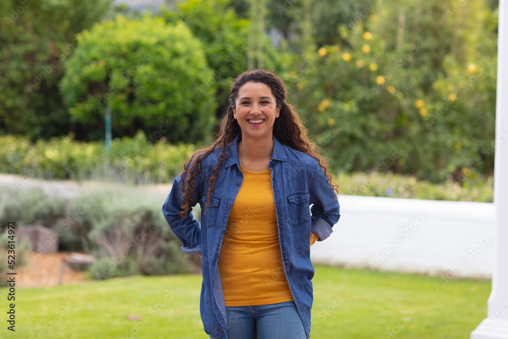 Image of happy biracial girl looking at camera in garden Image of happy biracial girl looking at camera in garden