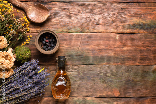 Herbal medicine concept background. Dry natural ingredients and remedy bottle on the wooden table flat lay background with copy space.