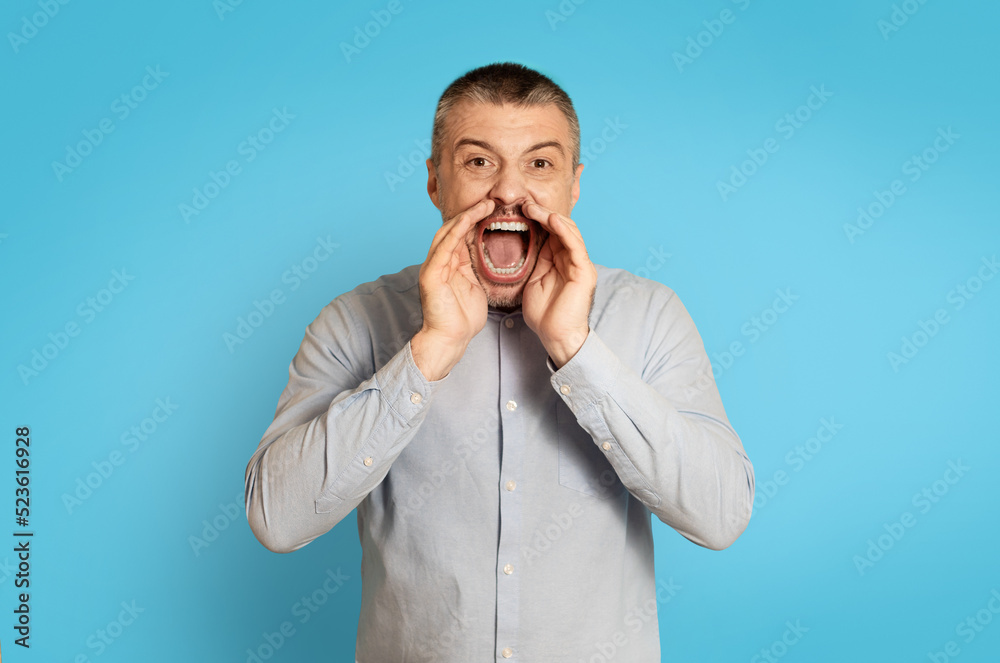 Emotional Middle Aged Man Shouting Announcing Offer Over Blue Background Emotional Middle Aged Man Shouting Announcing Offer Over Blue Background