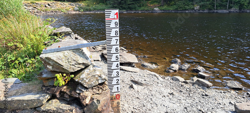 Drought in Llyn Llywelyn, Beddgelert Forest, Wales as water measure by edge of the lake indicates how very low the water has become. photo