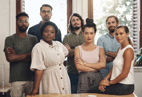Serious business people standing with arms crossed, looking confident and showing teamwork in an office together at work. Portrait of diverse creative employees expressing power, unity and success