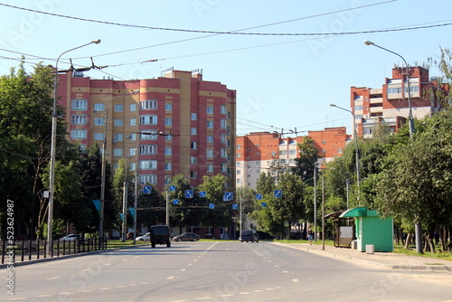 In summer, a city street with a three-lane road for cars. photo