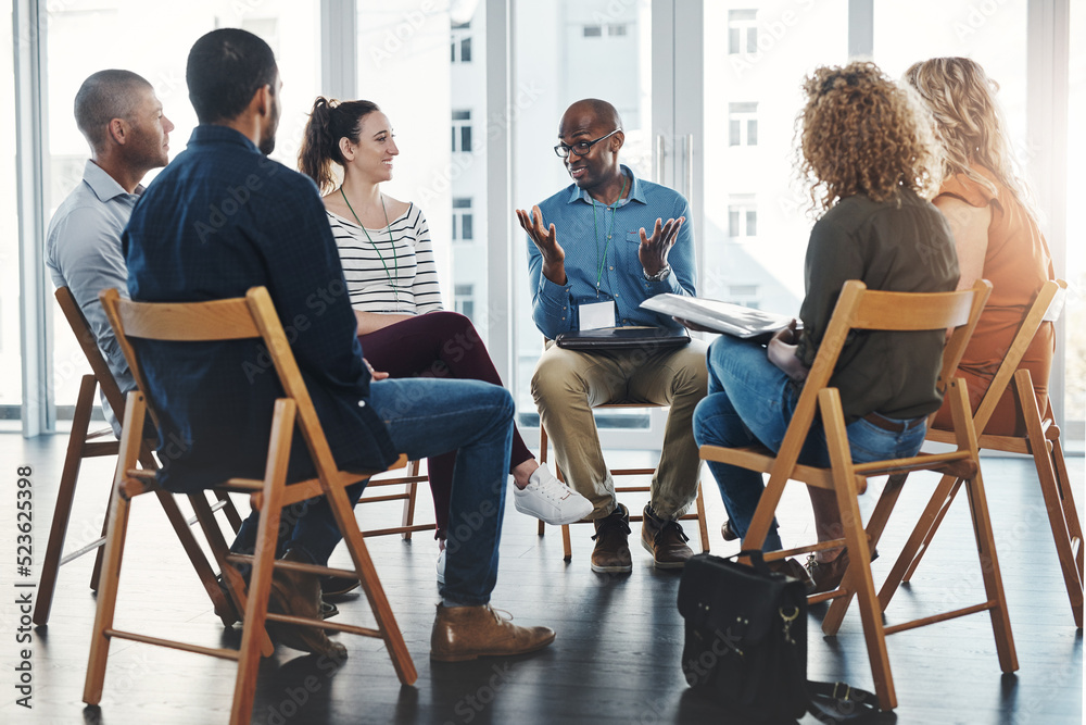 Business people in an informal meeting, team building discussion or group project planning session. Leader, manager or supervisor talking to diverse colleagues or employees about workflow management