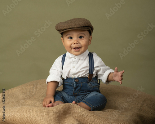 Cute funny baby dressed up like a newsboy 