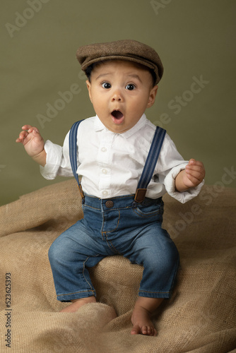 Cute funny baby dressed up like a newsboy 