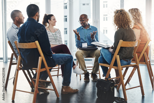 Business people in an informal meeting, team building discussion or group project planning session. Leader, manager or supervisor talking to diverse colleagues or employees about workflow management