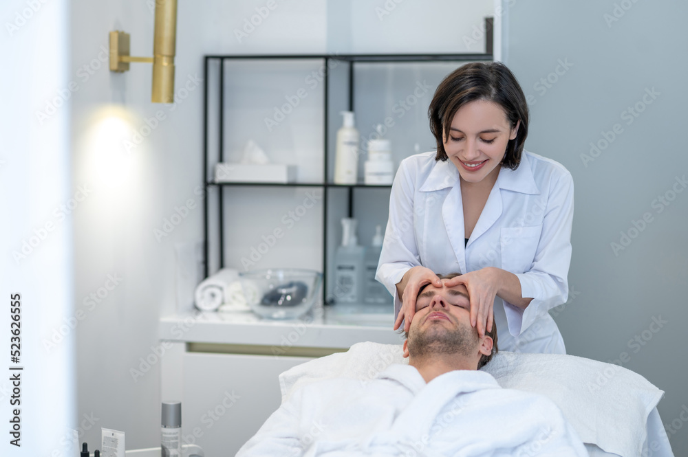 Young male client having face massage in a professional salon Young male client having face massage in a professional salon