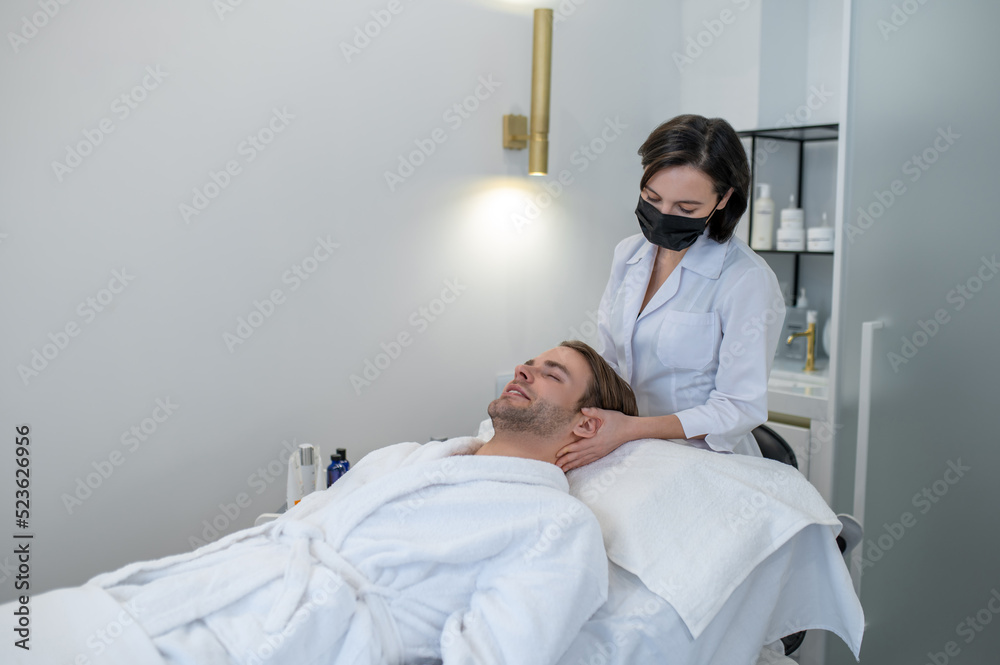 Female specialist in a protective mask working with a customer in a beauty salon Female specialist in a protective mask working with a customer in a beauty salon