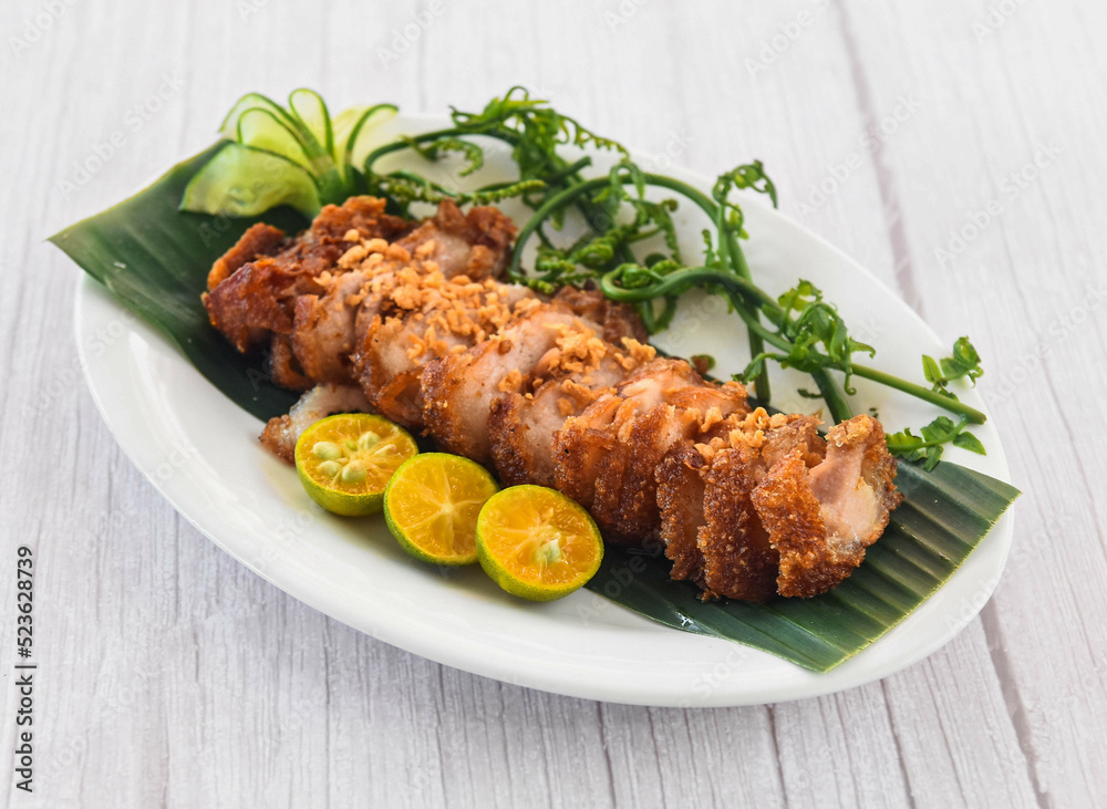 Crispy Bagnet with lime served in dish isolated on grey wooden background side view of fastfood Crispy Bagnet with lime served in dish isolated on grey wooden background side view of fastfood