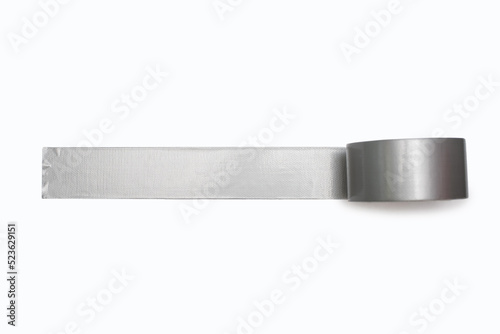 A spool of gray duct tape is unwound and pasted to a white background. Adhesive tape for repair work and construction. Adhesive tape for moisture protection or for assembly and packaging photo