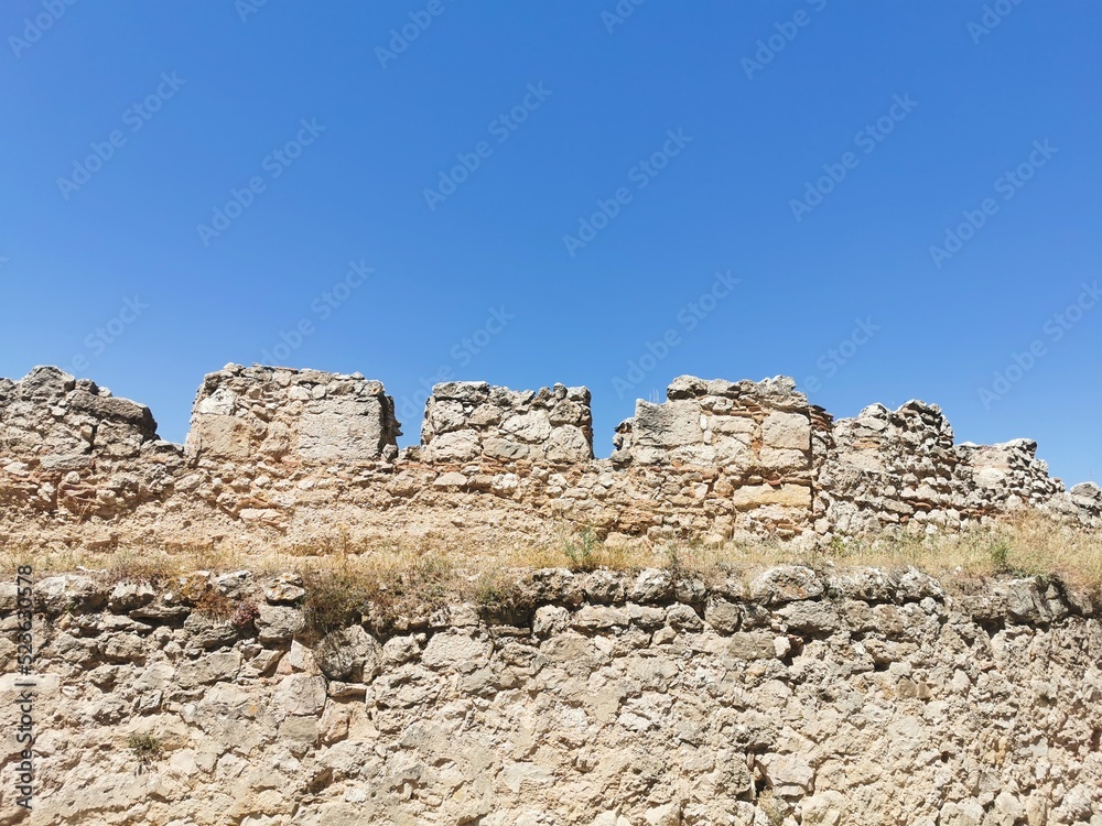 medieval castle wall background, made of stones, with a blue sky background, copyspace, without people.