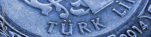 Translation: Turkish lira. Fragment of 1 lira coin close up. National currency of Turkey. Blue tinted horizontal stories for news about economy or finance. Money and bank in Turkey. Macro © Deacon docs