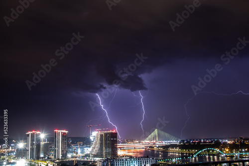 Very cloudy sky, lightning and thunder above the Belgrade sky, panoramic view of the city and the river with bridges. Belgrade is the capital of the Republic of Serbia