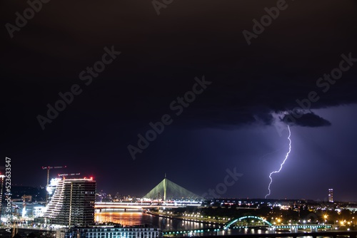 Very cloudy sky, lightning and thunder above the Belgrade sky, panoramic view of the city and the river with bridges. Belgrade is the capital of the Republic of Serbia