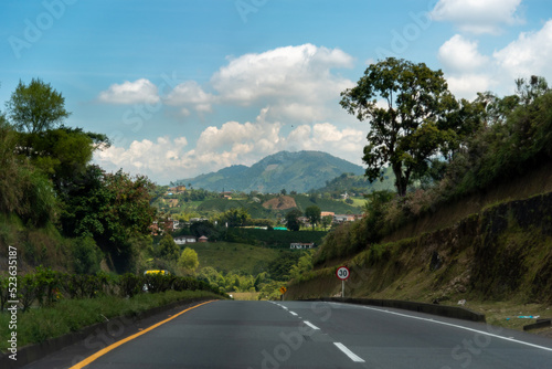 Road between small hills with mountain landscape in the background. Colombia.