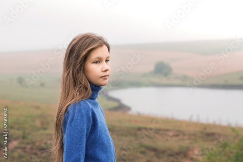 girl on a walk in a foggy morning near the lake