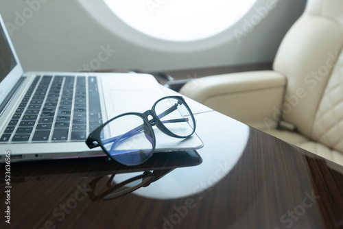 computer and glasses on a luxury jet inside 
