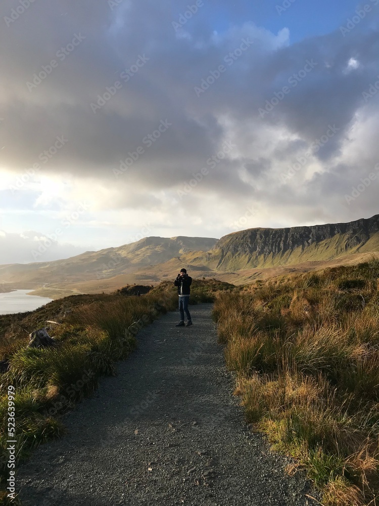 Fototapeta premium Mountain Man hiking in the mountains at sunset with a rising sun and amazing view 