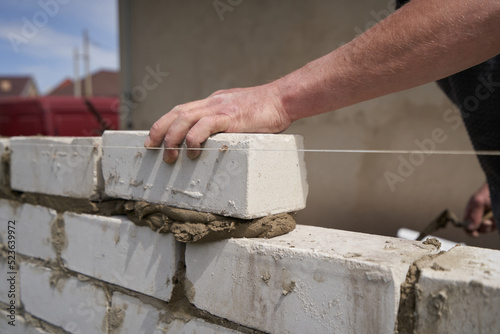 Tableau sur toile Builder bricklayer builds walls from bricks, close-up