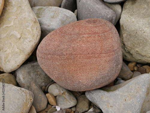Large red pebble on beach on Flotta island, Orkney