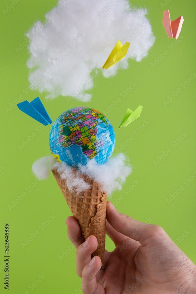Earth globe and colorful paper airplanes in waffle cone for icecream in