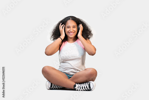 giovane ragazza isolata su sfondo bianco ascolta la musica con le cuffie  photo