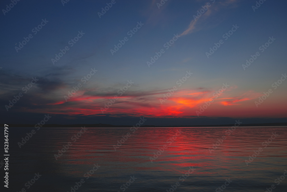 Sunset on the sea. Background image with clouds and reflection.